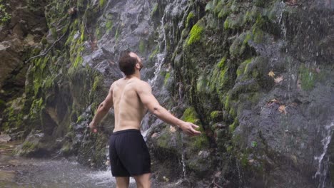 Sportlicher-Mann-Steht-Vor-Wasserfall.-Zeitlupe.