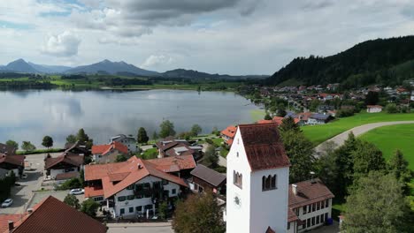 lago hopfensee y ciudad ciudad de hopenfen en suabia baviera alemania antena de drones sobre la torre de la iglesia