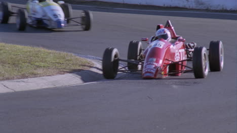 two race cars head into a sharp turn on a track