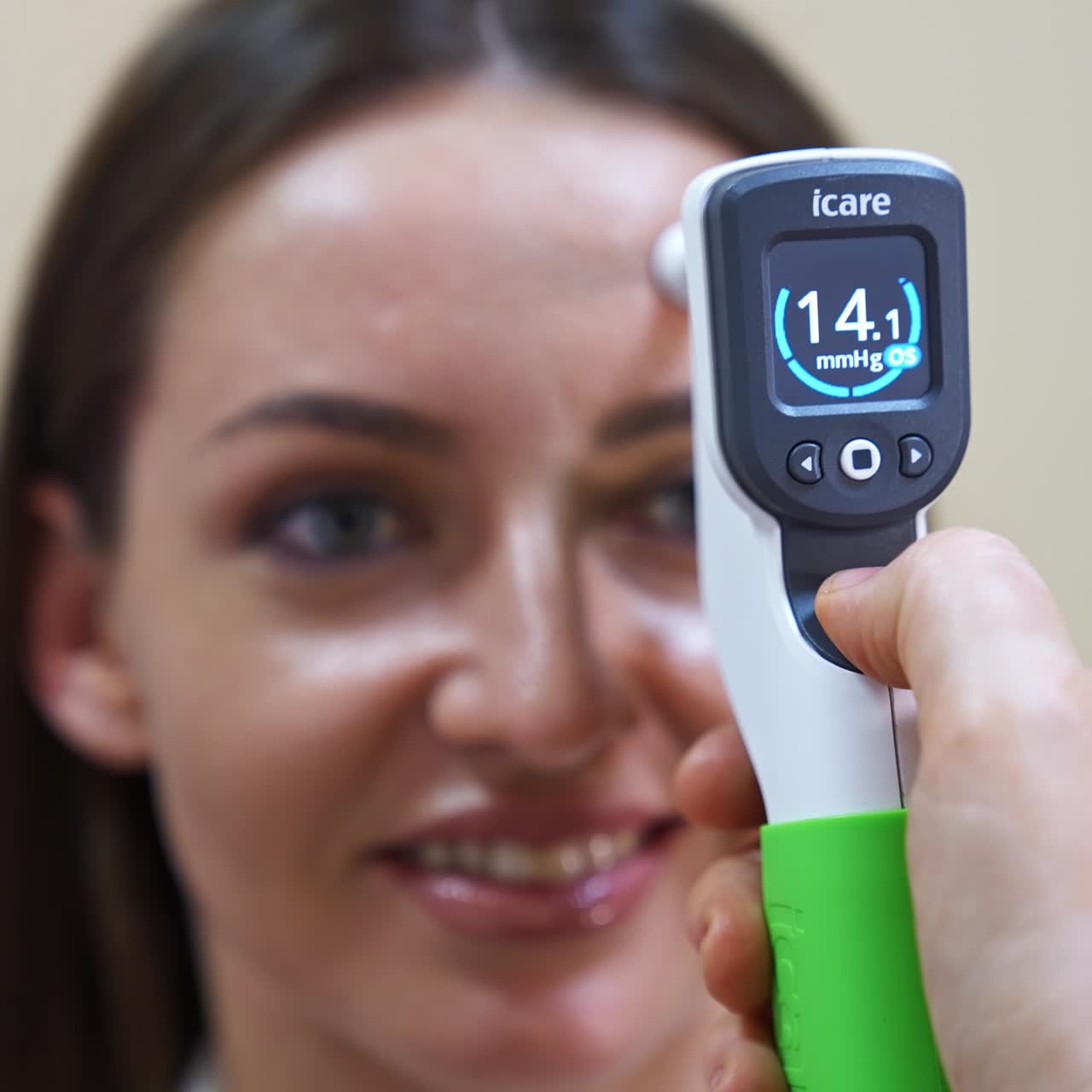 Hand of an ophthalmologist holds a device attached to a patient's forehead. Young woman at oculist's check up. Close up