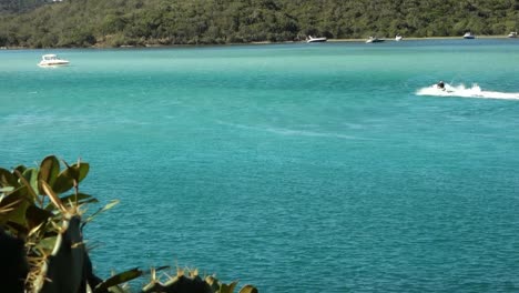 Jet-ski-and-yachts-sailing-along-blue-sea-channel-at-summer-daytime