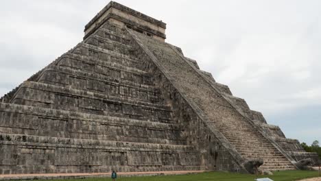 temple of kukulcan and the stairs with the heads of the feathered serpents at the base of the stairways at chichen itza