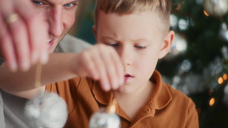 father and son decorating christmas tree during holidays