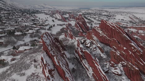 fresh snow sunny afternoon roxborogh state park golf course aerial drone colorado front range winter spring deep powder dramatic sharp red rocks mountain landscape littleton denver forward pan up