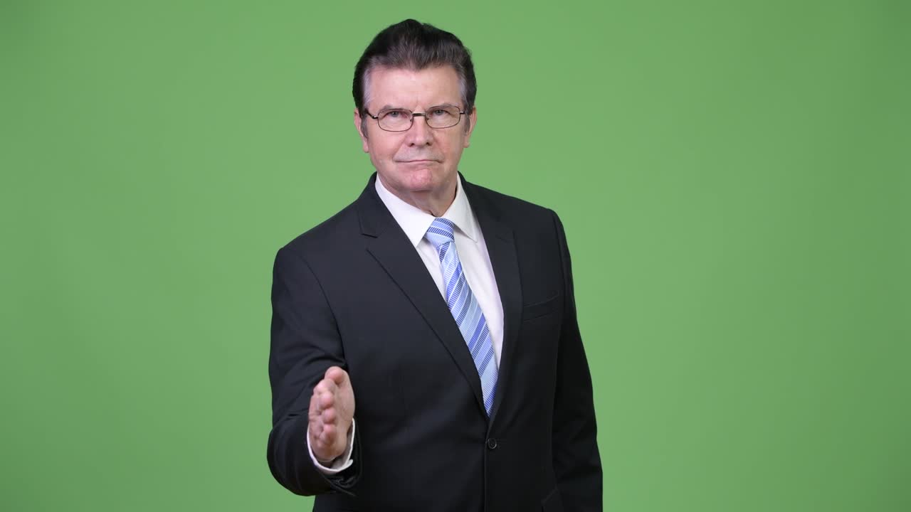 Senior handsome businessman giving handshake