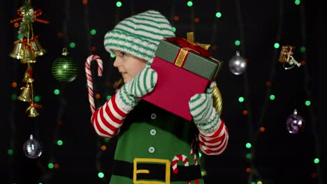 Kid-child-in-Christmas-elf-Santa-Claus-helper-costume-holding-present-surprise-gift-box-with-ribbon