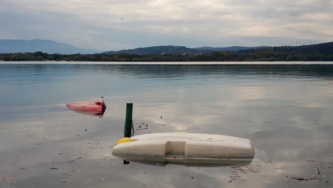 Vista-De-Bloqueo-De-Dos-Barcos-Volcados-Flotando-En-Aguas-Del-Lago-Después-De-La-Tormenta