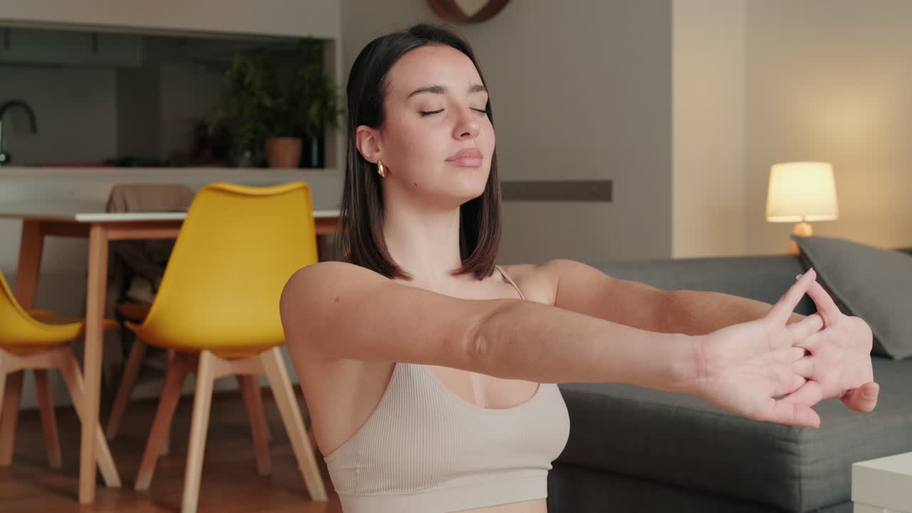 mujer joven haciendo yoga en casa