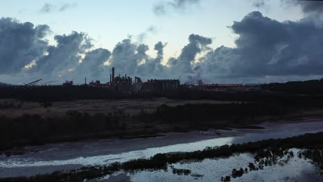 disparo de drones volando hacia la fábrica de carbón y metal al amanecer, grandes pilas de humo operando