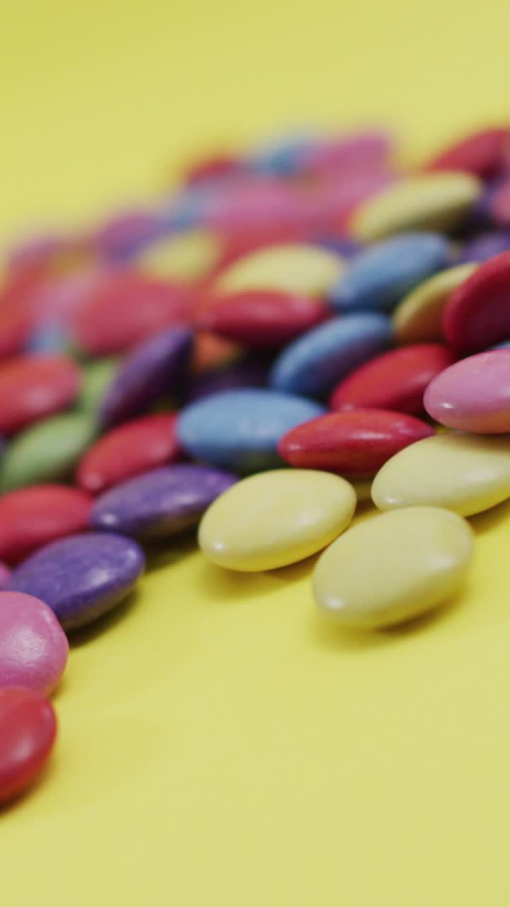 video de lentejas multicolores sobre un fondo amarillo