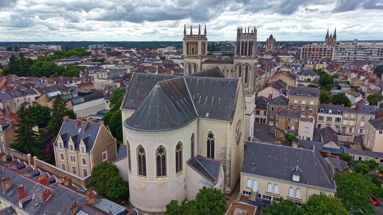 Drone che si allontana e sale dietro la Chiesa di San Giuseppe, rivelando lo storico paesaggio urbano di Angers dall'alto