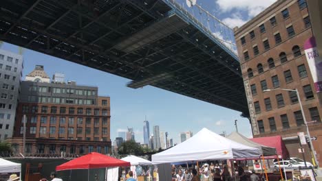 a bustling street market under a bridge in new york city