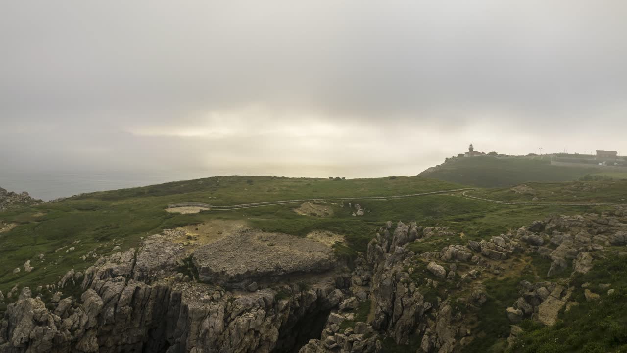 облака тумана над травянистой скалой