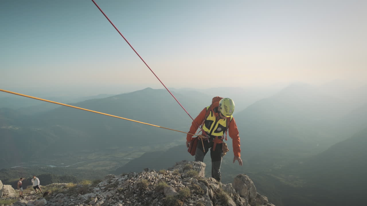 excursionista descendig fron la roca hacia abajo con pequeños pasos hacia atrás