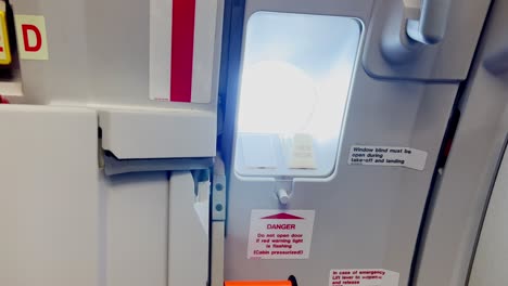 zoom in on airbus airplane galley window with door closed and armed during flight