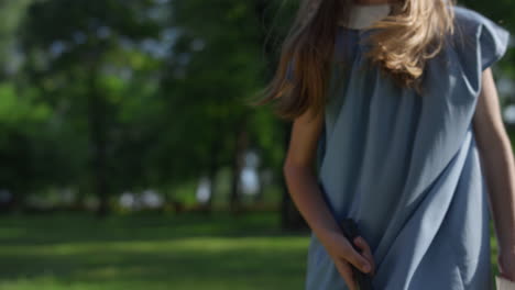 Focused-girl-hit-shuttlecock-toss-in-park.-Playful-blond-child-pose-alone