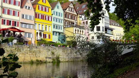 cute little old colorful german river town tübingen buildings with citizens chilling and relaxing while enjoying the sun