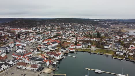 antena de gran altitud sobre la ciudad de lillesand en el sur de noruega - volando lentamente hacia atrás mientras revela la ciudad completa y el puerto deportivo