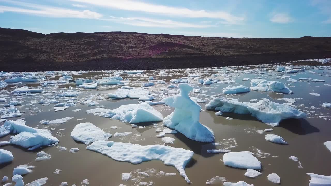 Slow aerial across the massive glacier lagoon filled with icebergs at Fjallsarlon Iceland suggests global warming and climate change 15
