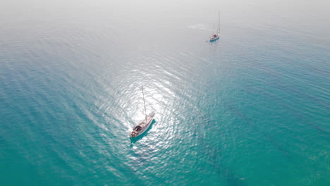 Dos-Pequeños-Veleros-Flotando-En-Agua-Azul-Turquesa