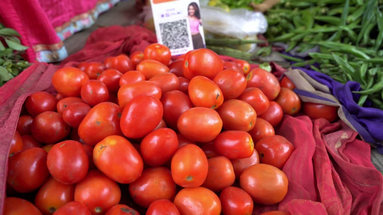 Fresh red tomatoes for sale, Vegetable vendor using UPI QR code for cashless payments
