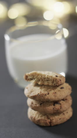 vertical video of mug of milk and christmas cookies and copy space on black background