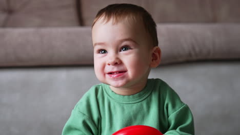 baby playing with red ring toy