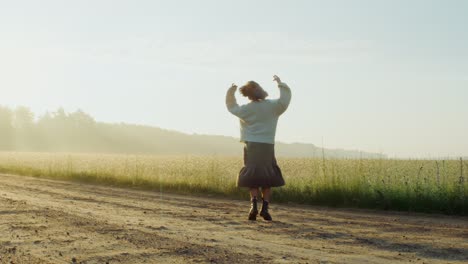 woman walking in a wheat field at sunrise