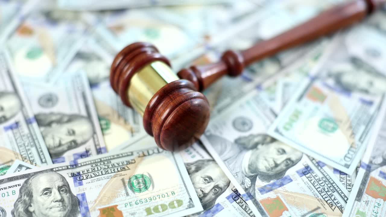 Gavel on a pile of hundred dollar bills