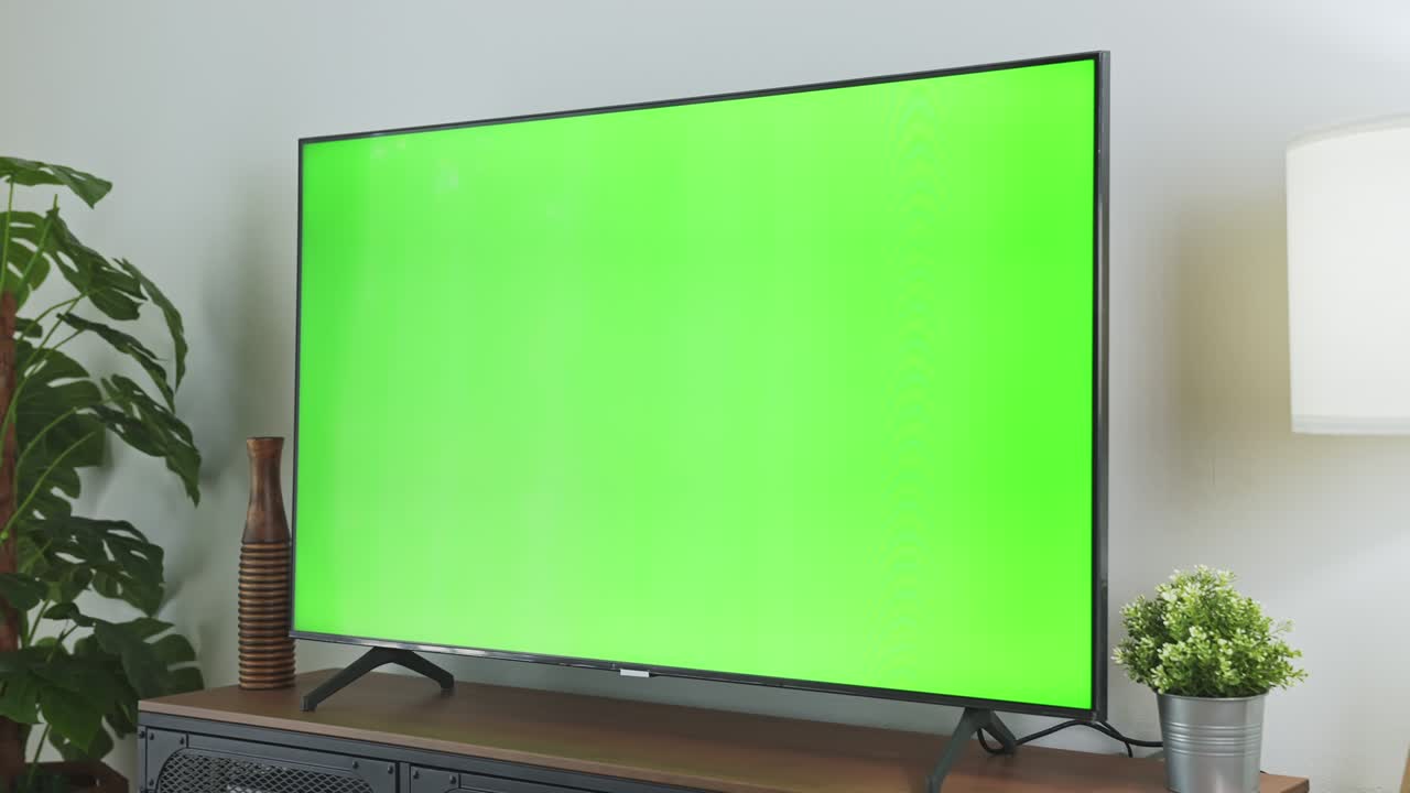 TV Green Screen in living room with tree and lamps. chroma key screen for advertising.