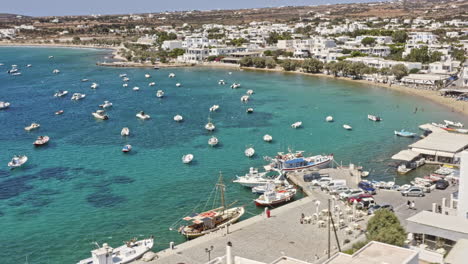 aliki paros greece aerial v3 birds eye view capturing seaside and hillside fishermen village with fishing boats moored on beautiful clear blue aegean sea - september 2021