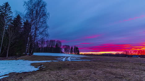 Ländliche-Waldlandschaft-Mit-Schneeschmelze,-Sonnenuntergang-Im-Zeitraffer-Mit-Fliegenden-Wolken