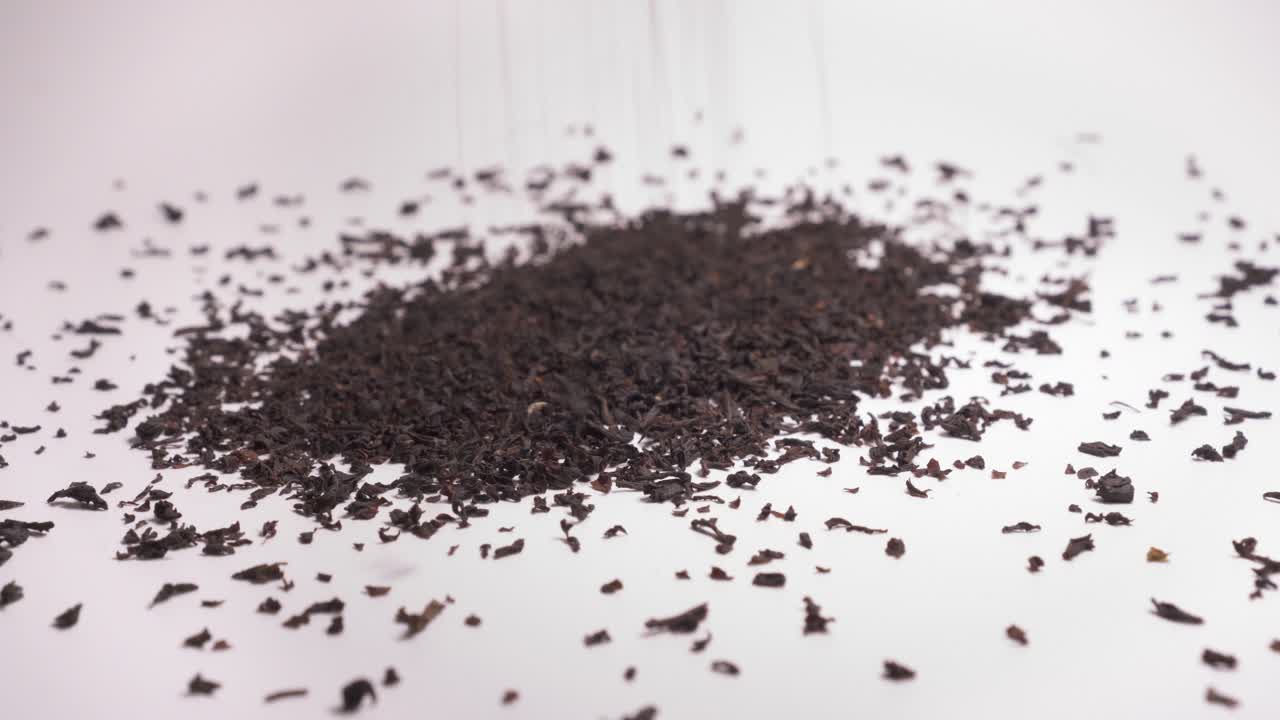 Tè nero che cade su sfondo bianco - primo piano