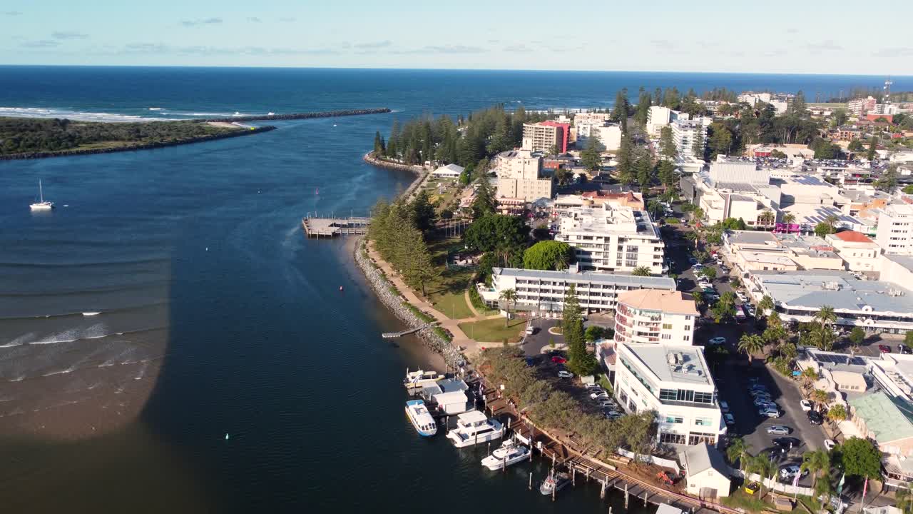 Drone aerial shot of Hastings River inlet channel with Port Macquarie town centre rural tourism buildings boats Pacific Ocean Mid North Coast NSW Australia 4K