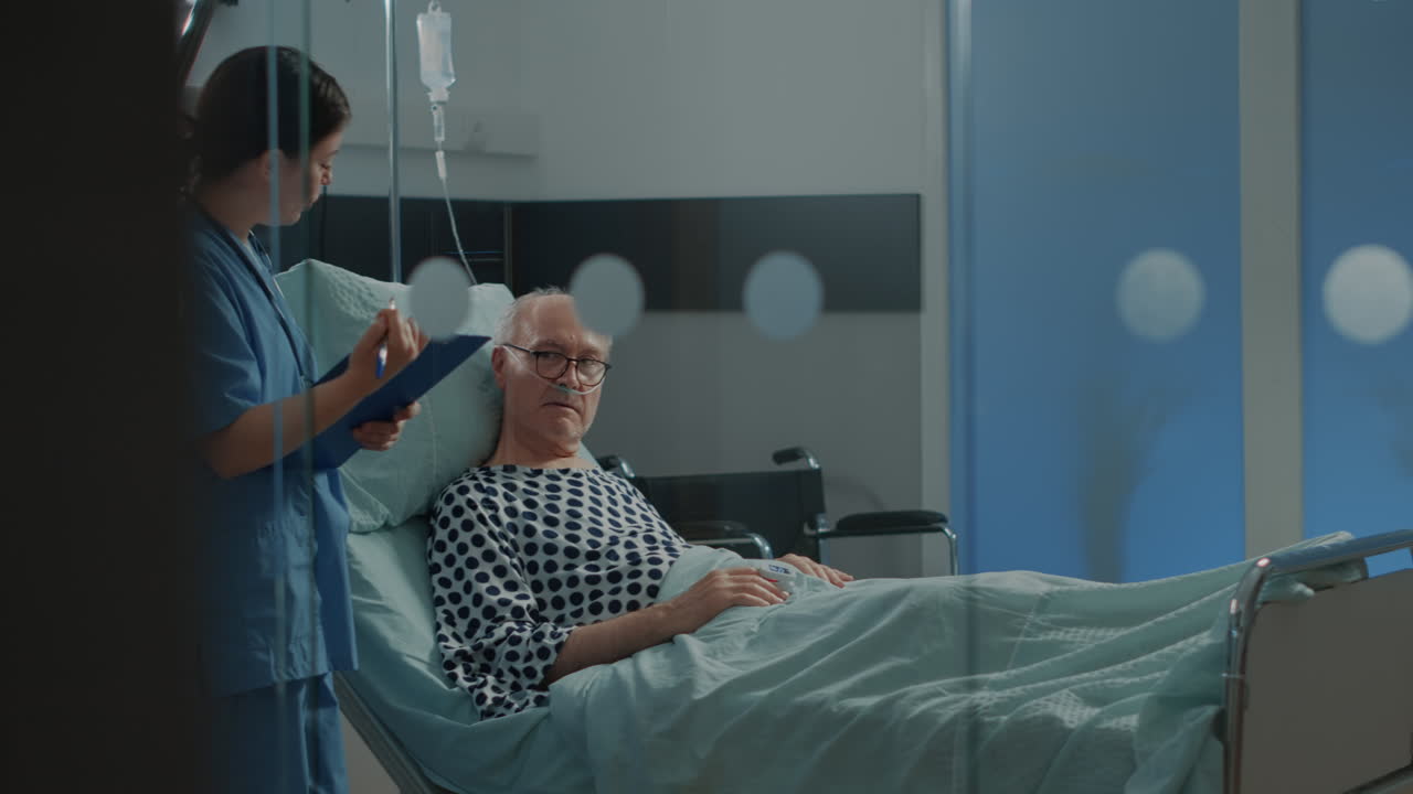 Caucasian nurse checking on elder patient in hospital ward
