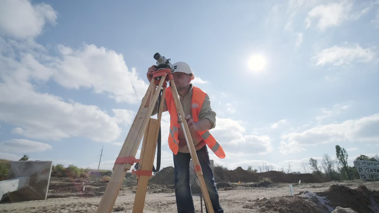 un ingeniero topógrafo toma mediciones en la construcción de una subestación de transformador