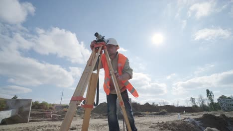 un ingeniero topógrafo toma mediciones en la construcción de una subestación de transformador