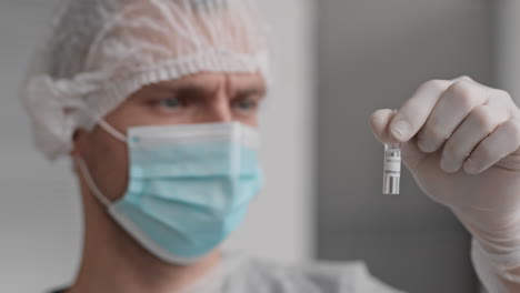 laboratory worker looking at covid-19 vaccine