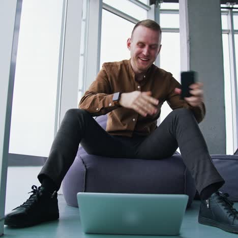 handsome businessman writing notes from smartphone at modern office