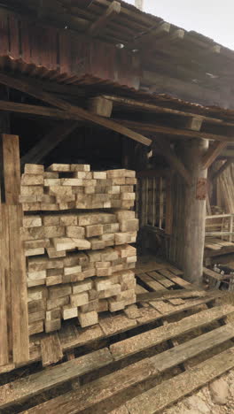 old wooden barn with stacks of lumber