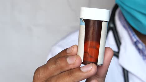médico con un frasco de pastillas