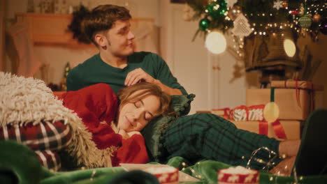 Woman-resting-on-male-friend's-lap-sitting-on-blanket