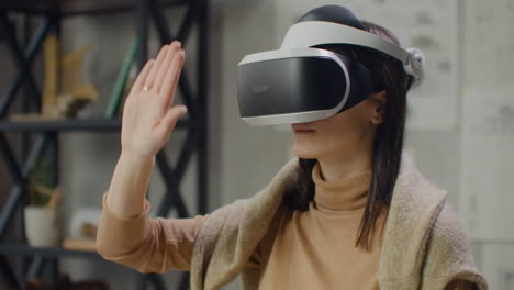 female engineer in virtual reality helmet with hands imitates work of interface. designing the future the concept of virtual architecture and design interface graphic applications.