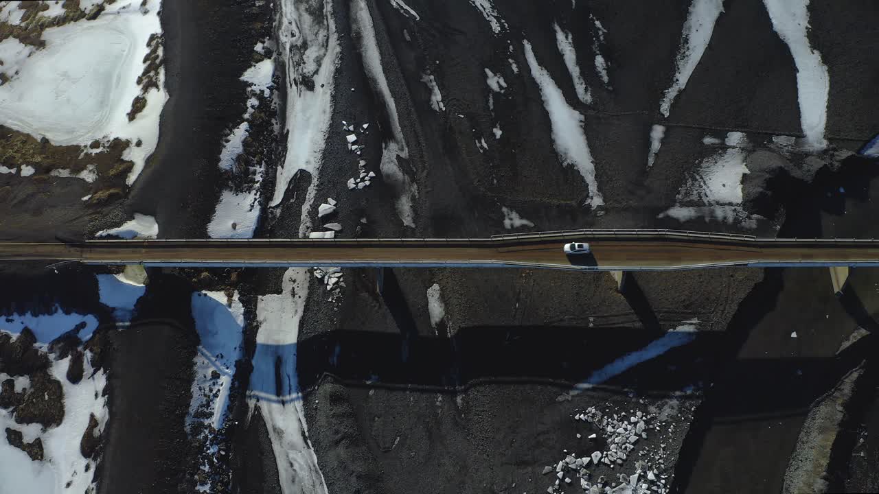 coche blanco conduciendo en el puente sobre el río con nieve y hielo