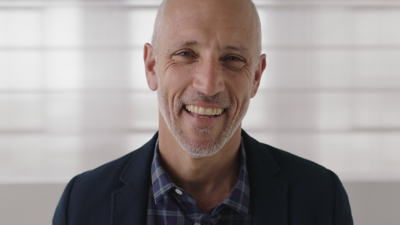 retrato en primer plano de un atractivo hombre de negocios maduro riendo feliz mirando a la cámara disfrutando del éxito