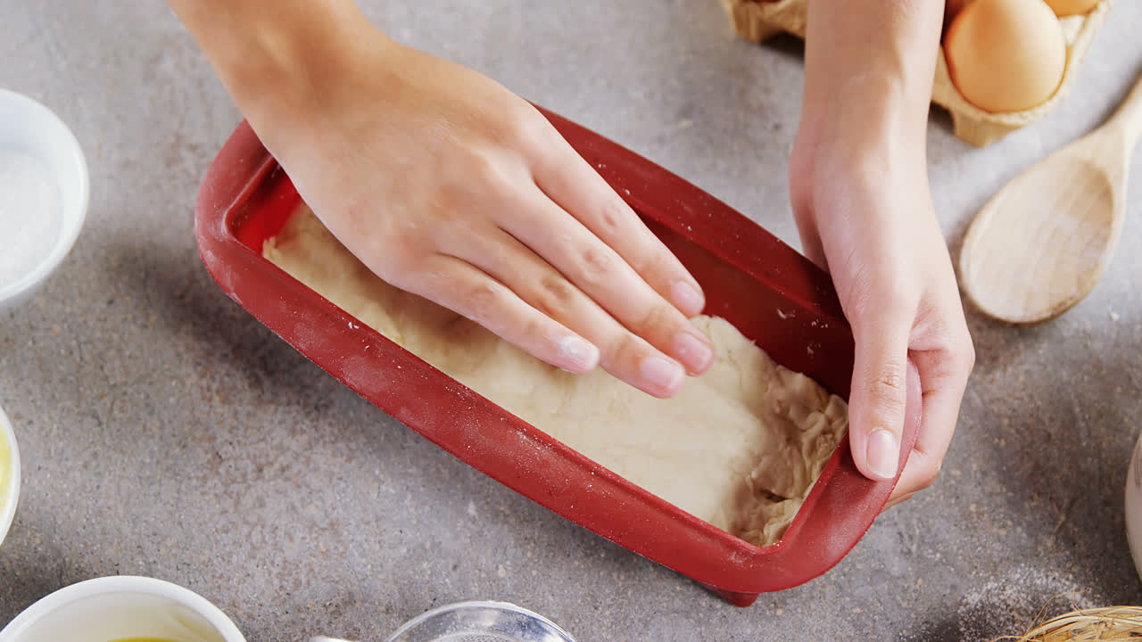 mujer preparando masa rodeada de varios ingredientes 4k