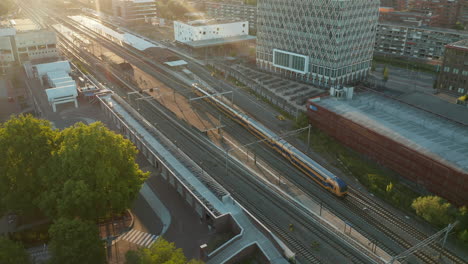 Vista-Aérea-Del-Tren-Interurbano-Ns-Que-Viaja-En-La-Estación-De-Gouda,-Países-Bajos