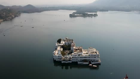 Ascenso-Aéreo-Sobre-El-Palacio-Del-Lago-Taj-En-El-Lago-Pichola,-Udaipur,-Rajasthan,-India