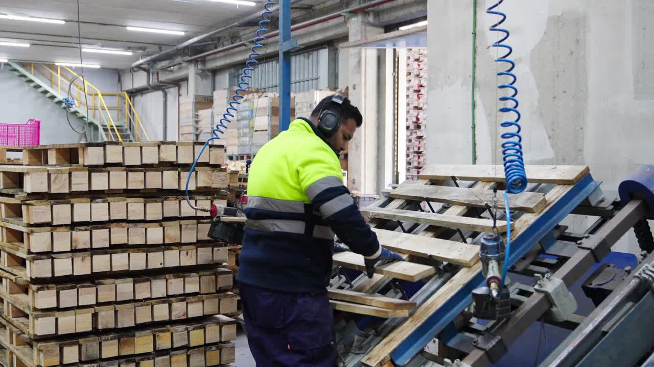 Operaio che assembla pallet in fabbrica