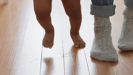 happy baby learning to walk toddler taking first steps with father helping infant teaching child at home